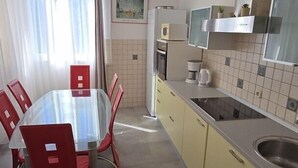 A compact kitchen with a dining table and chairs, a built-in oven, a microwave, and a sink. - Apartment Coraline on Korcula, seafront (Smokvica)