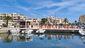 A marina with boats docked, a building labeled 'PORT DE BORMES,' and palm trees.