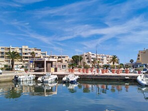 A marina with boats docked, a building labeled 'PORT DE BORMES,' and palm trees. - Air-Conditioned Studio Near Beach with Pool and Parking in Bormes-les-Mimosas (Bormes-les-Mimosas)