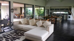 En moderne stue med sofa, spiseplads og køkken.