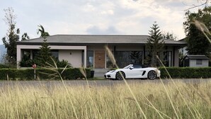 Et moderne hus med en hvid cabriolet foran.