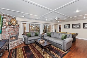 A living room with a fireplace, a pool table, and a sofa. - Tranquility Lodge by Destination Big Bear : Luxury in Castle Glen Estates! Pool Table! (Big Bear Lake)