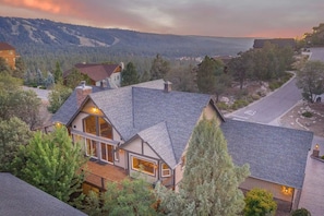 A residential property with a prominent house featuring a large front porch, a garage, and a driveway.