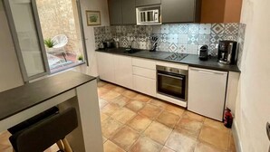A compact kitchen with a microwave, coffee maker, and oven. - 'The Ucetia' appt in charming stone house in Uzès centre (Uzès)