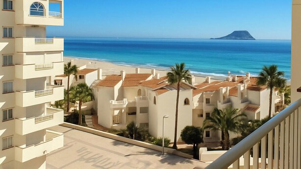 Une vue sur la côte, prise depuis un balcon donnant sur une plage, avec une montagne en arrière-plan.