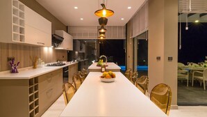 Una cocina moderna con una isla central, armarios empotrados y un comedor con sillas.
