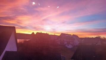 A sunset over a residential area with houses and a clear sky.