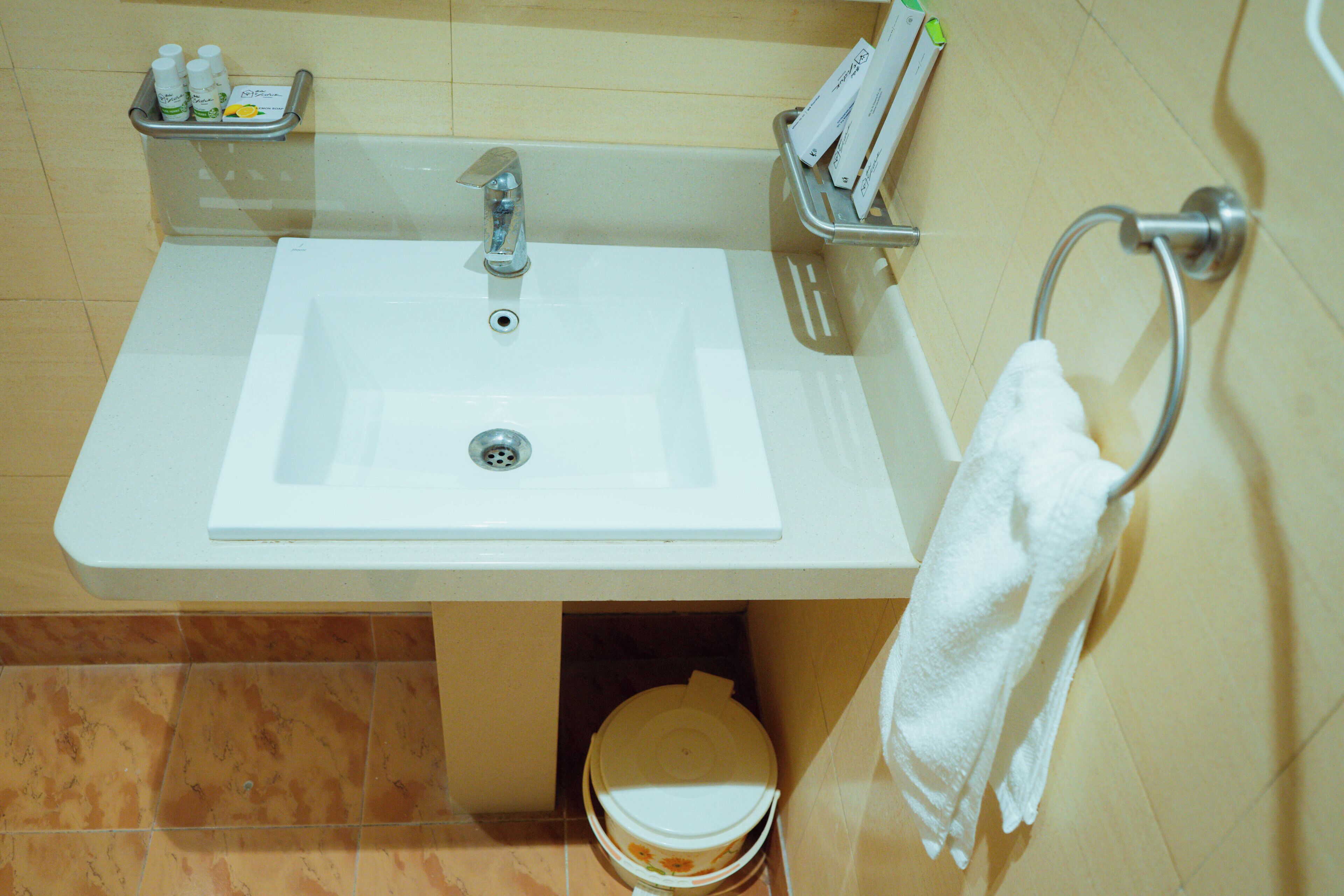 A bathroom with a white sink, a toilet, and a towel rack.