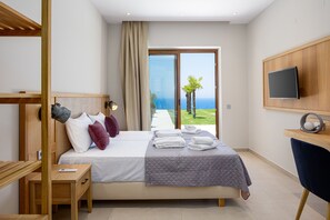 A modern hotel room with a large bed, a desk, a TV, and a view of the ocean. - Dream vacation with stunning sunsets at Villa Violetta (Kissamos)