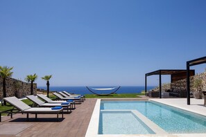 A poolside area with lounge chairs, a hammock, and a view of the ocean. - Dream vacation with stunning sunsets at Villa Violetta (Kissamos)