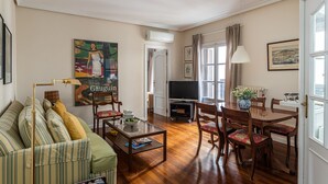Una sala de estar con sofá, mesa de centro, televisor y comedor.