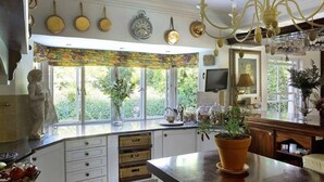 Uma cozinha com janela saliente, uma estátua, um relógio e um candelabro.