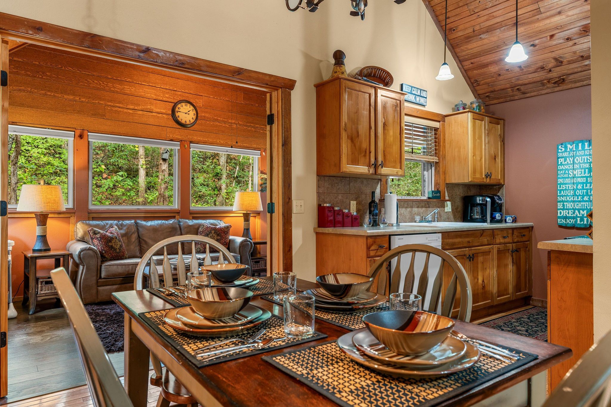 A cozy dining area with a wooden table set for four, surrounded by wooden chairs.