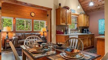 A cozy dining area with a wooden table set for four, surrounded by wooden chairs.