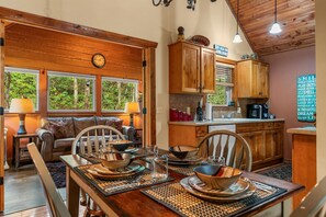 Un comedor acogedor con una mesa de madera dispuesta para cuatro personas, rodeada de sillas de madera.