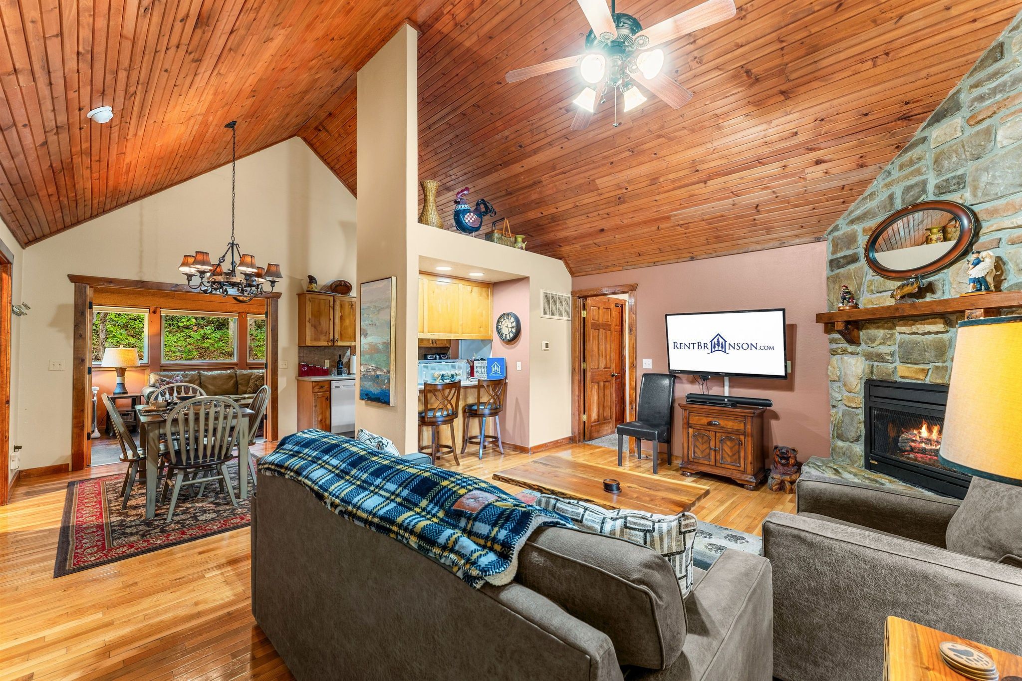 A spacious living room with a fireplace, a television, and a dining area with a wooden table and chairs.