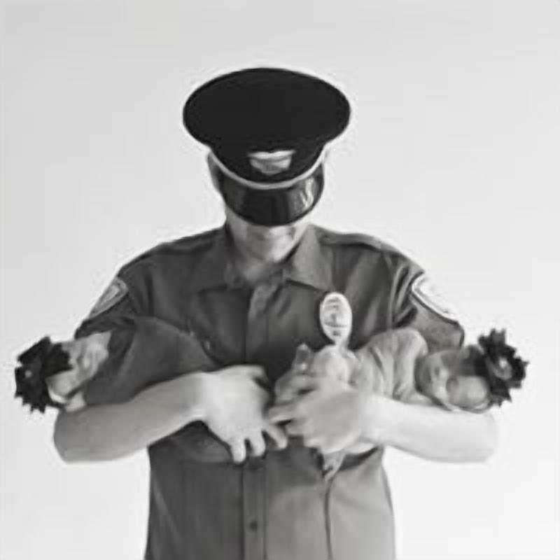 A person in a uniform holding a baby.