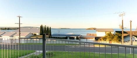Zona residencial com vista para o mar, casas com painéis solares e propriedade cercada.