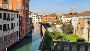 A canal lined with historic buildings, narrow waterway, and a distant tower. - Hotel Cannaregio 2357 (Venice)
