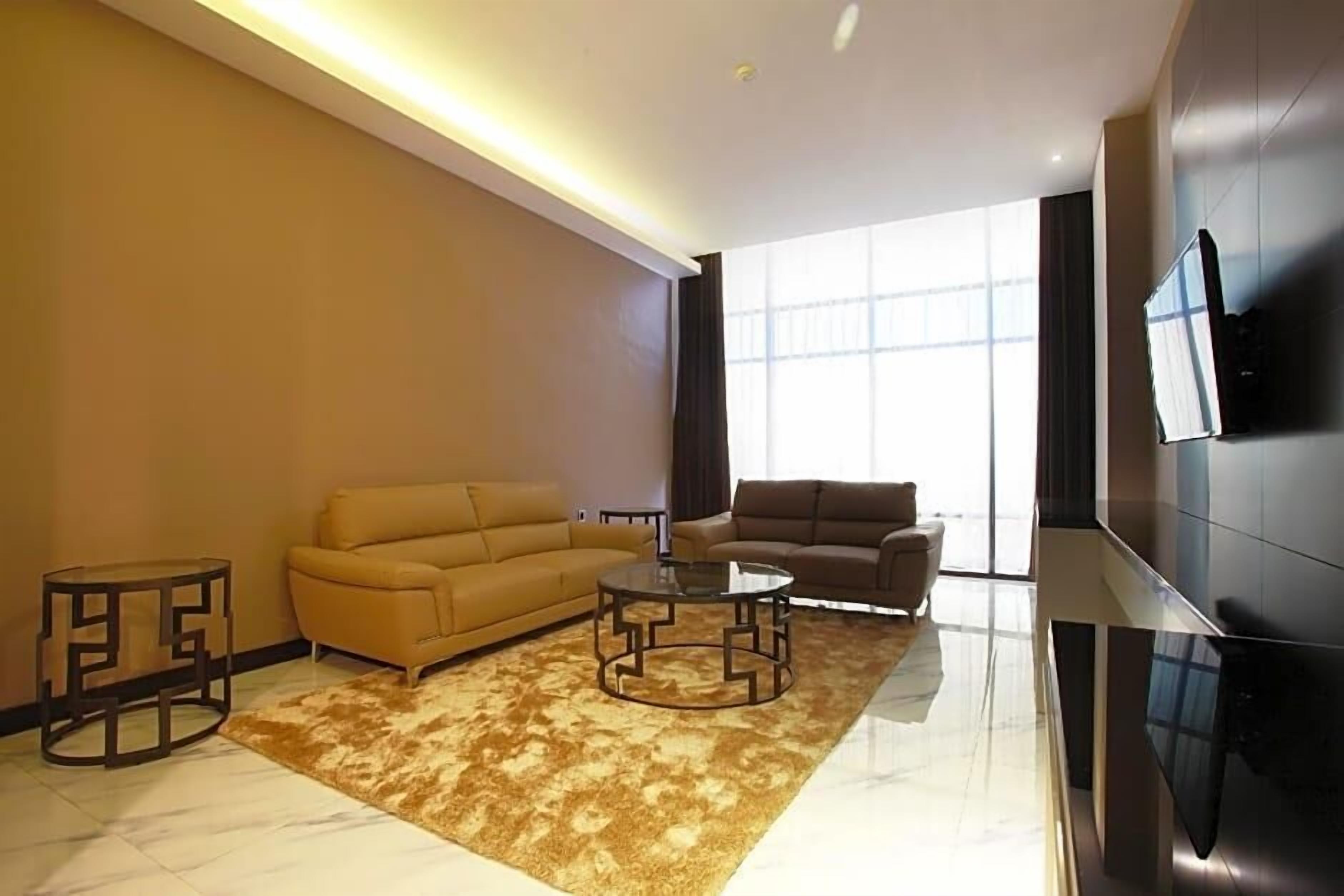 A modern living room with a sofa, a coffee table, and a TV mounted on the wall.