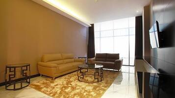 A modern living room with a sofa, a coffee table, and a TV mounted on the wall.