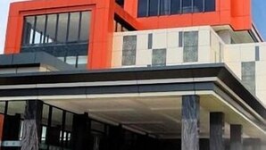 A modern building with a prominent red and black facade, large windows, and a covered entrance area. - Grand Karlita Purwokerto (Purwokerto)