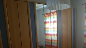 Ein Schlafzimmer mit einem Bett, einem Kleiderschrank und einem Spiegel.