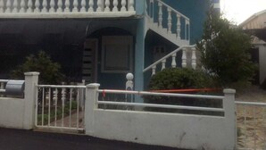Ein zweistöckiges Haus mit Balkon und Treppe.