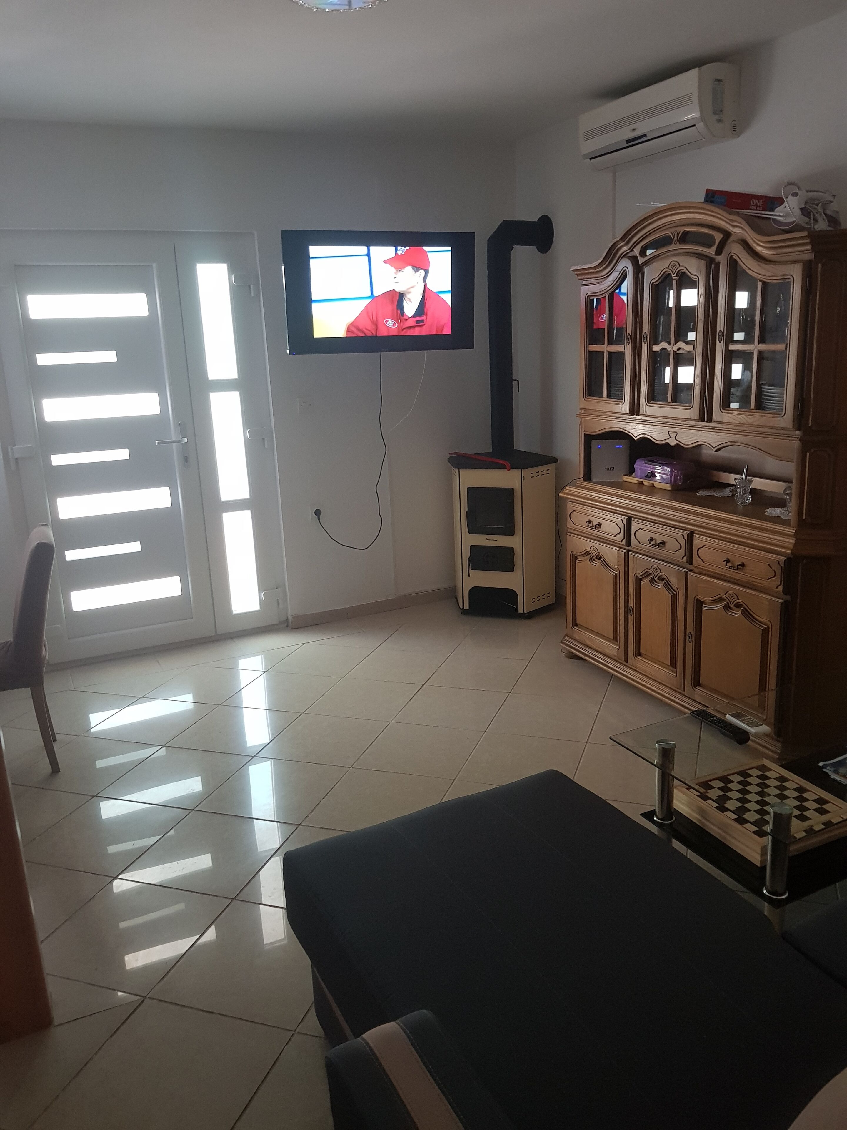 Ein Wohnzimmer mit Fernseher, Schrank und Sofa.