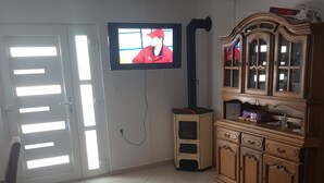 Ein Wohnzimmer mit Fernseher, Schrank und Sofa.