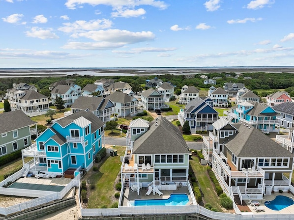 A coastal residential area with houses featuring balconies and a swimming pool. - Why Knot 4 bedroom in The Currituck Club (Corolla)