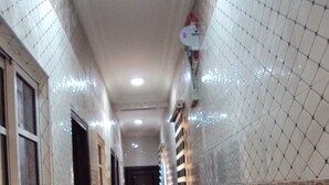 Un pasillo con piso de cuadros, paredes de azulejos y una puerta al final.