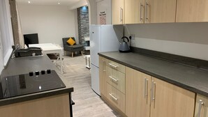 Una cocina moderna con armarios de madera, encimera negra y estufa integrada.