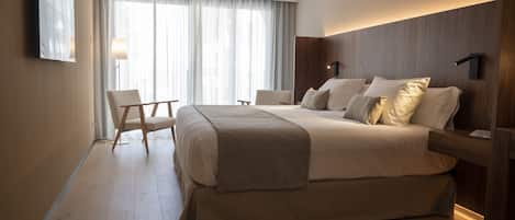 Una habitación de hotel moderna con una cama grande, un escritorio y una silla.