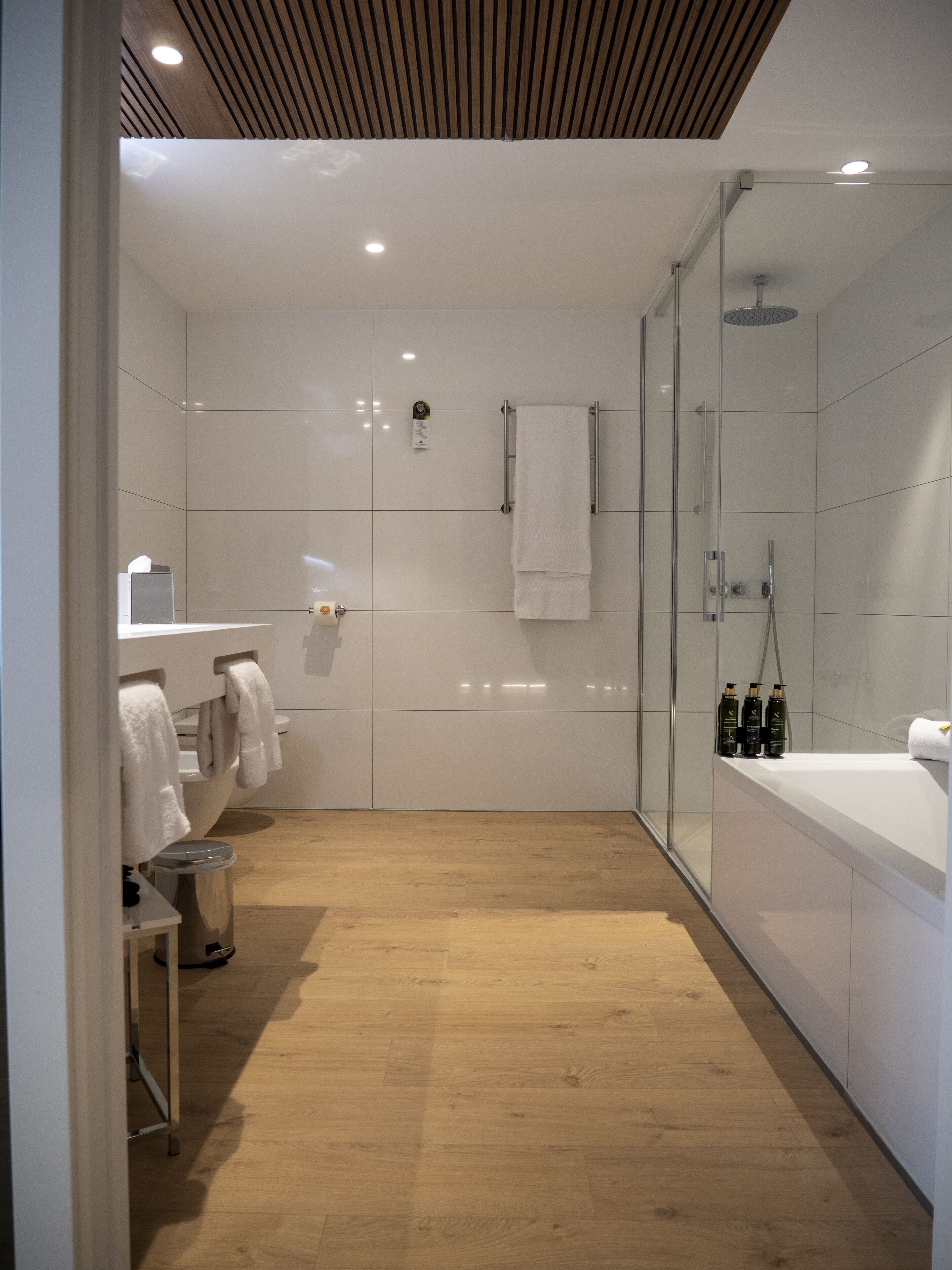 Un baño moderno con ducha, inodoro y lavamanos.