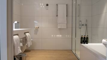 Un baño moderno con ducha, inodoro y lavamanos.