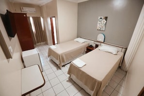 A hotel room with two single beds, a small table, a TV, and a window with curtains. - Serra Azul Plaza Hotel (Barra do Garcas)
