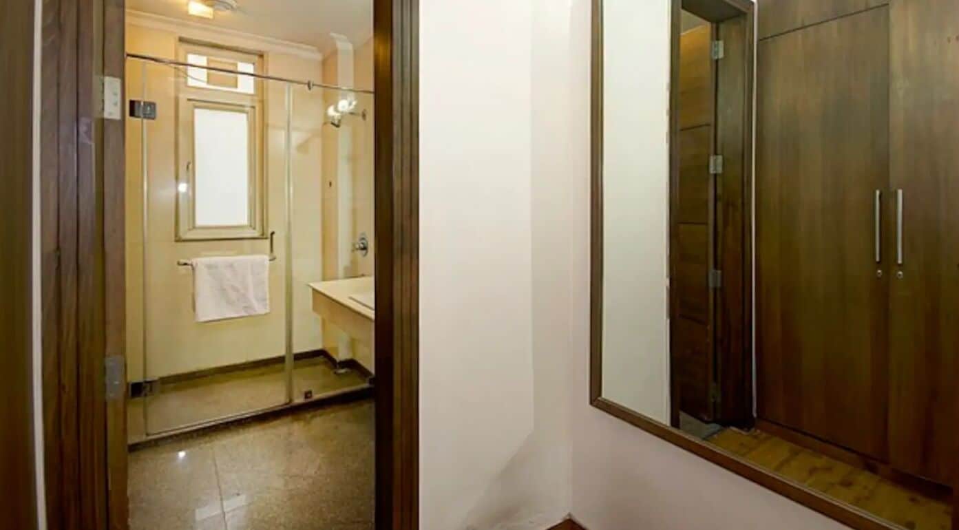 Une salle de bain avec une douche à parois de verre, un meuble-lavabo en bois et une serviette accrochée au mur.