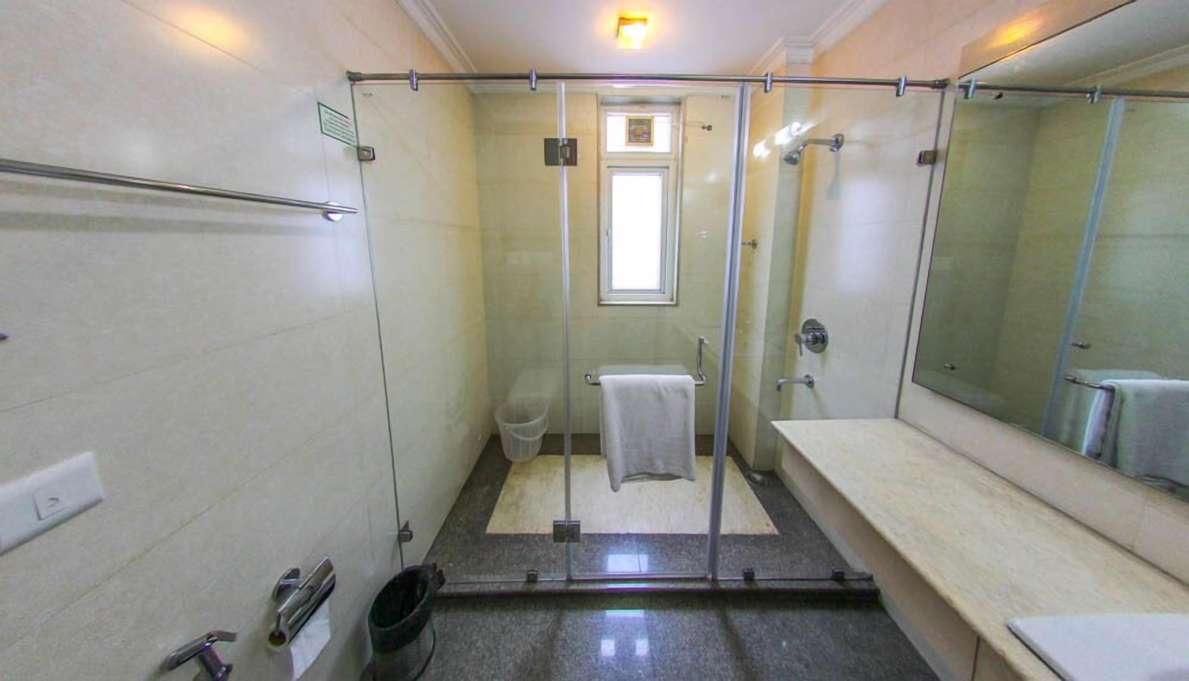 Un baño pequeño y moderno con cabina de ducha de vidrio, inodoro y lavamanos.
