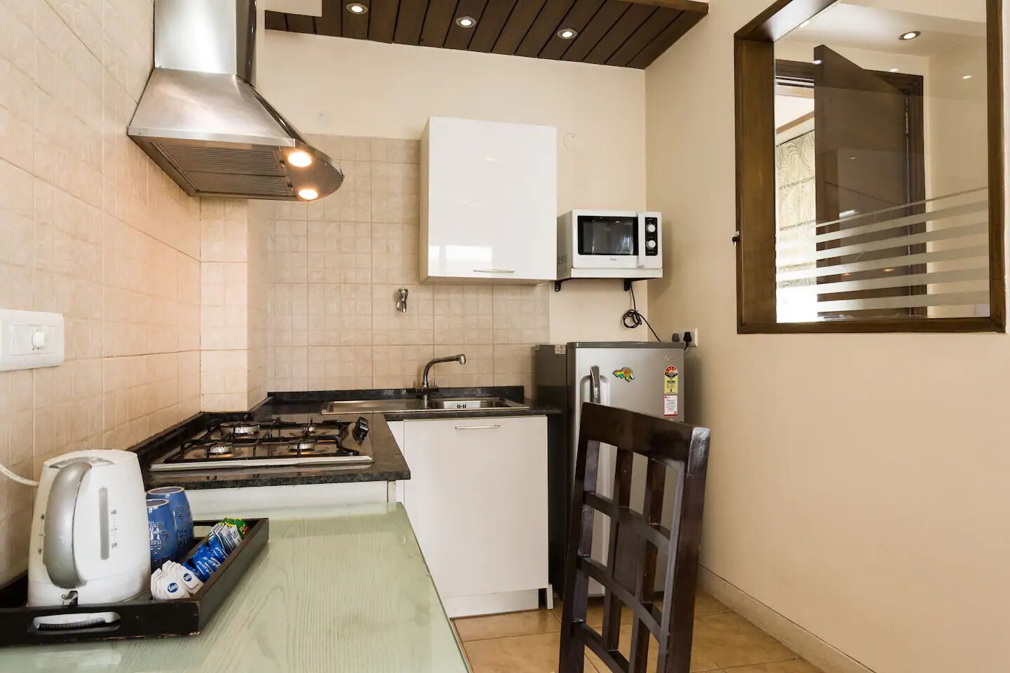 A compact kitchen with a gas stove, a microwave, and a refrigerator.