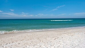A beach with clear blue water and a sandy shore.