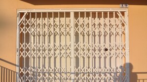 A white metal gate with a geometric pattern, attached to a beige wall, with a number plate 'A9' above it. - Welcome to our cozy apartment for rent in Roses, Costa Brava! Just 300 meters from the beautiful Santa Margarita beach. (Roses)
