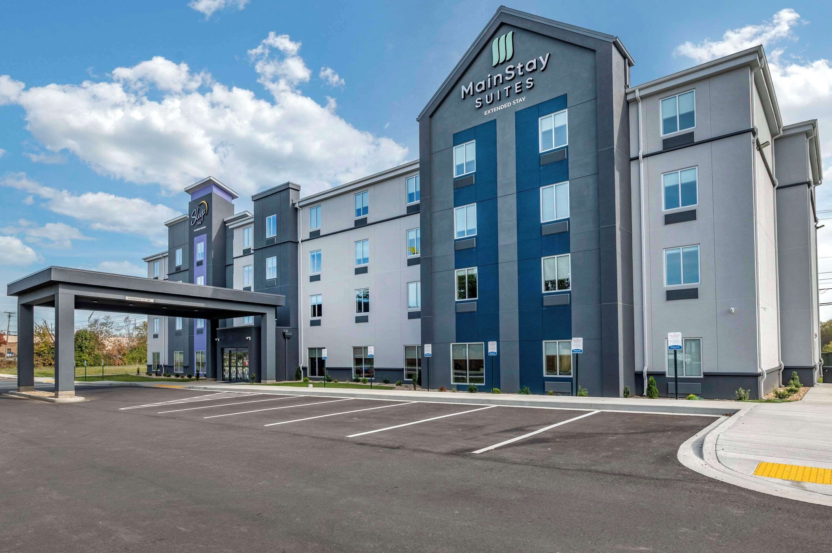 A MainStay Suites Extended Stay hotel with a modern design, multiple floors, and a covered entrance.