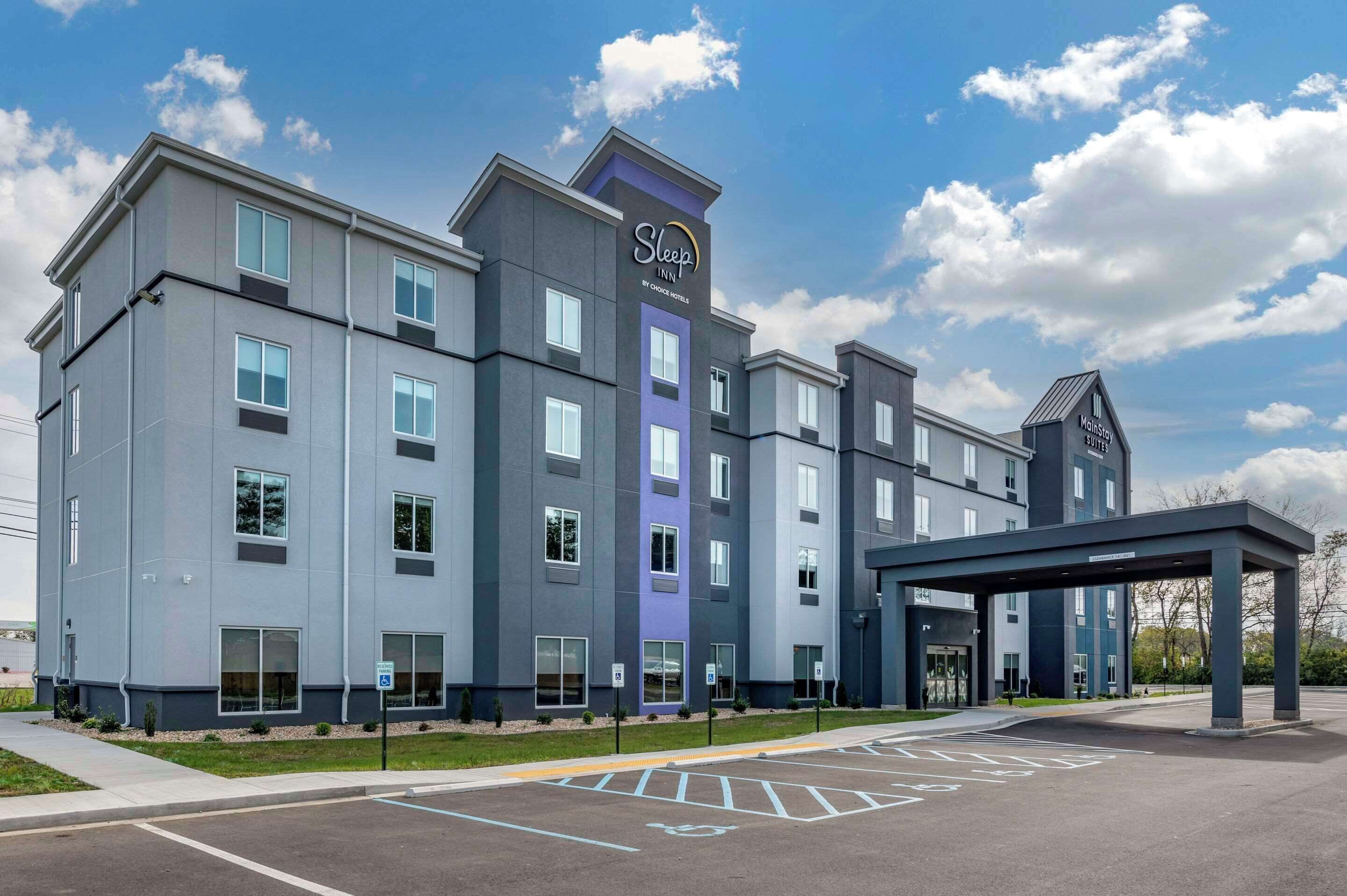 A multi-story hotel with a modern design, featuring a prominent entrance and a covered parking area.