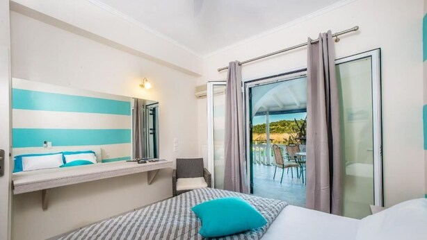 Habitación de hotel con una cama, una mesita de noche, una silla y vistas al exterior a través de un ventanal.