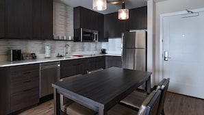 Una cocina moderna con armarios de madera oscura, electrodomésticos de acero inoxidable y una isla central con asientos.