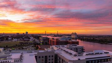 A cityscape at sunset with buildings and a river.
