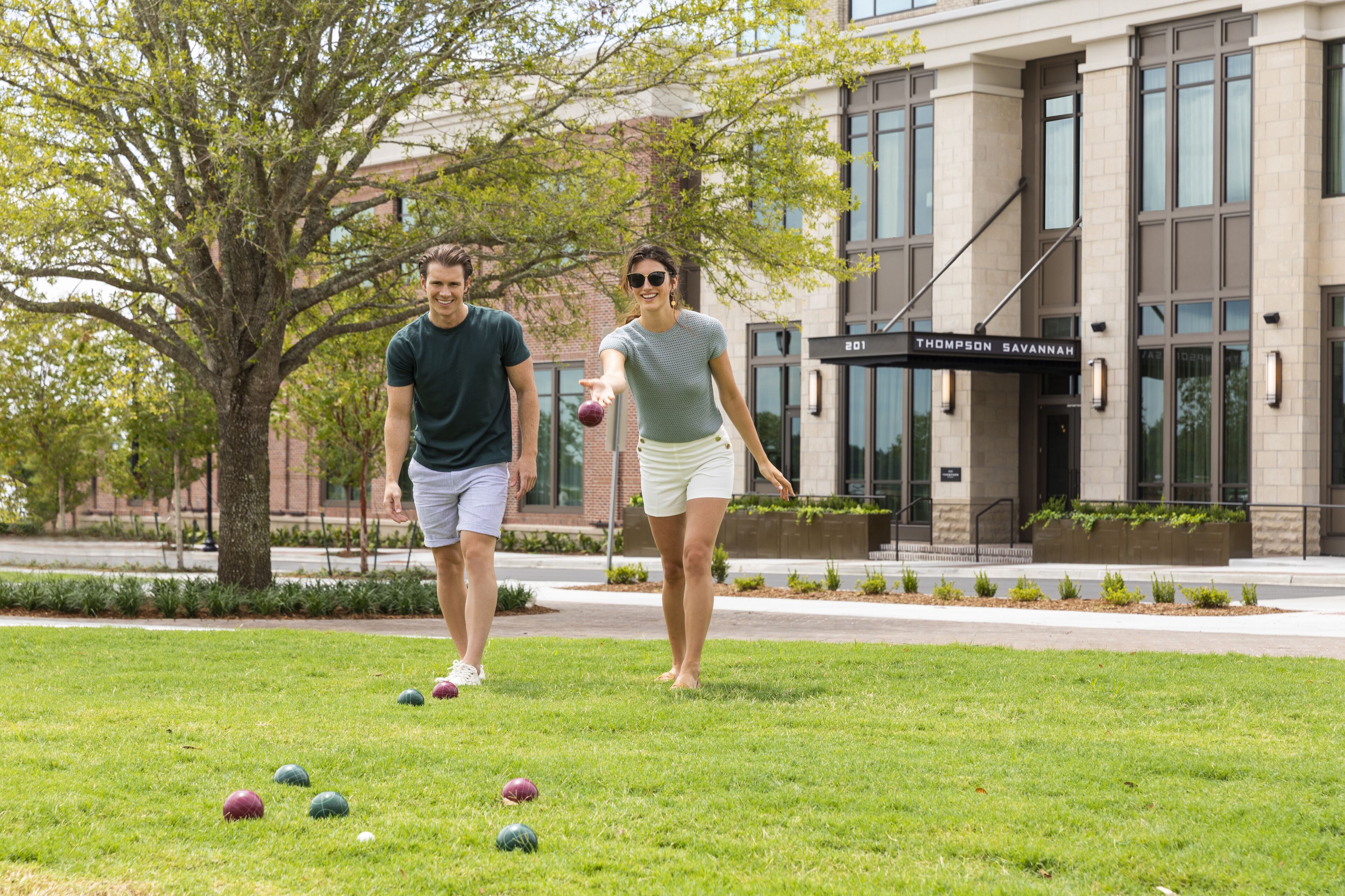Two people playing croquet in a grassy area with a building labeled "Thompson Savannah" in the background.