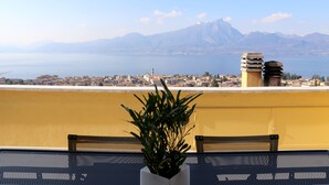 Un balcón con vistas a la ciudad y a las montañas.