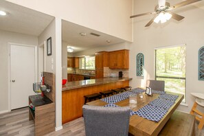 Enjoy meals in the kitchen with a sink and ample counter space, surrounded by a dining table and comfortable chairs.